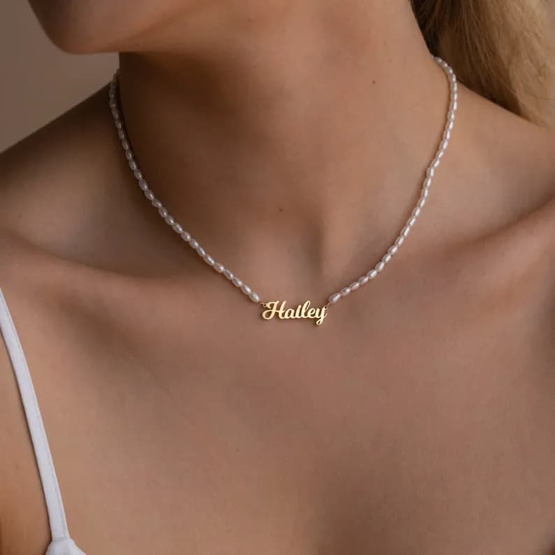 Delicate pearl necklace with a gold nameplate pendant that reads "Hailey".