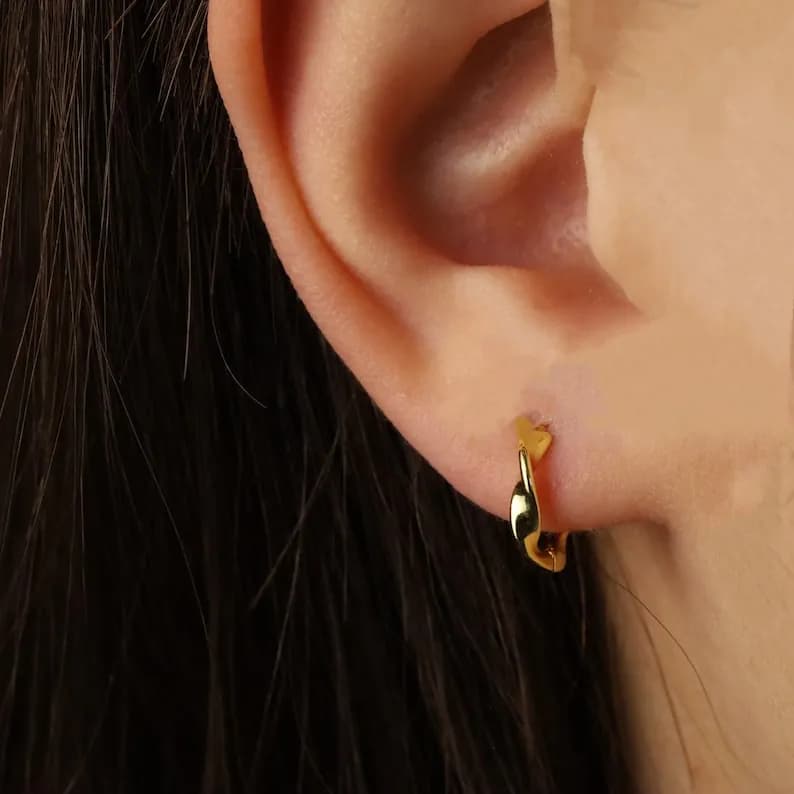 Gold hoop earrings with a twisted design. The earrings are small and delicate.