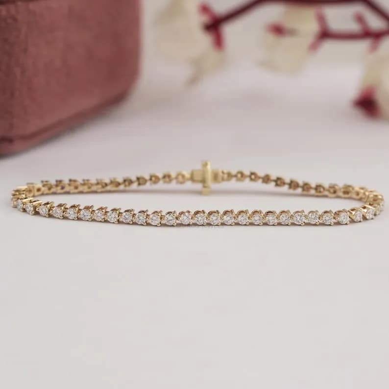 Delicate gold tennis bracelet with a row of sparkling round diamonds.