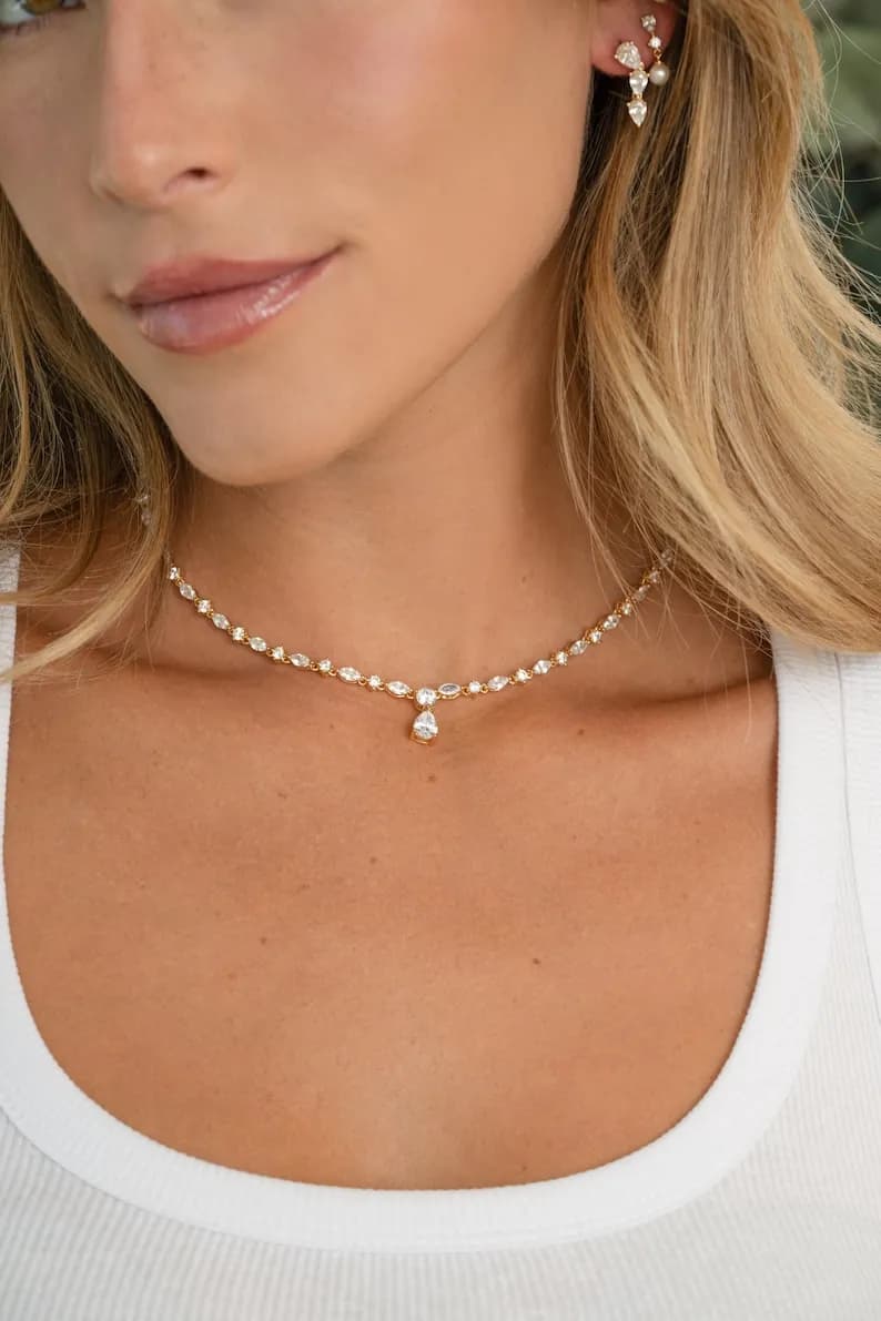 Model wearing gold tennis necklace, perfect as bridal jewelry