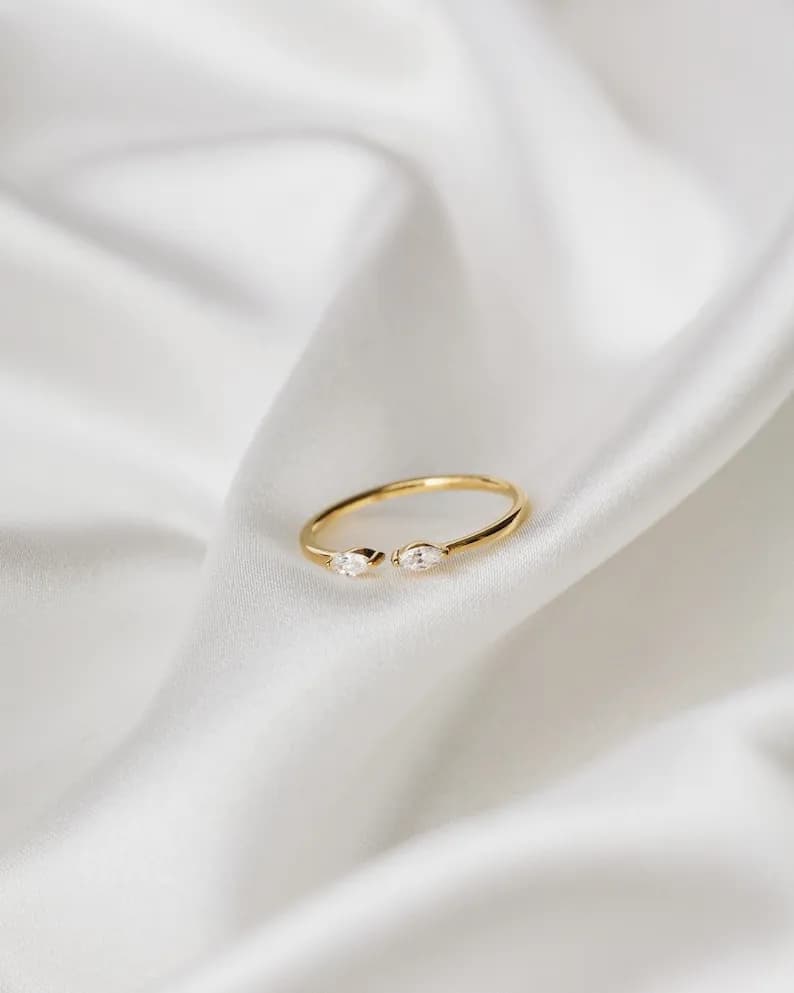 Gold ring with two marquise-shaped clear stones set on either side of the band.