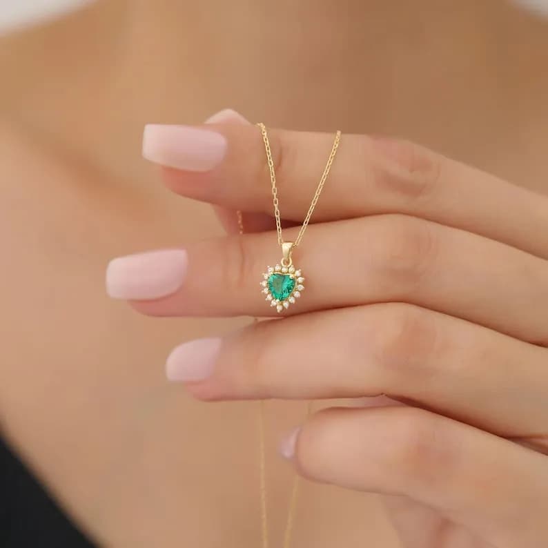 Emerald Heart Necklace featuring a green emerald surrounded by diamonds.